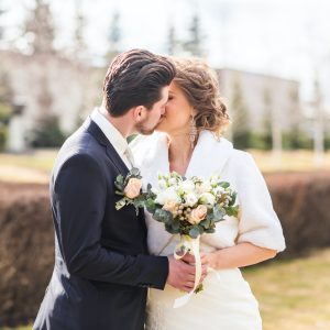 bride-and-groom-kissing-on-their-wedding-day-outdoors.jpg